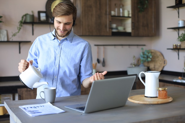 Confident man wearing headset speaking and watching business webinar training, listening to lecture.