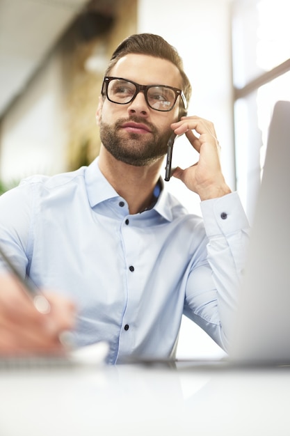 Confident manager being engaged in negotiations on the phone