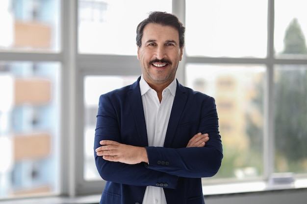 Confident middleaged man with a mustache wearing a blue suit and white shirt