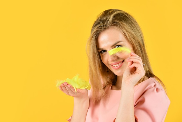 Confident model with makeup hold yellow feather cute smiling woman in dress trendy glamour lady summer fashion style pretty woman has stylish hair girl follow her fashion copy space