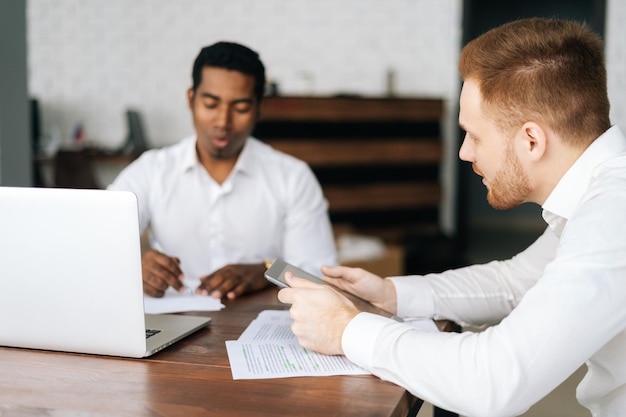 Confident multiethnic businessmen in formalwear having business team meeting