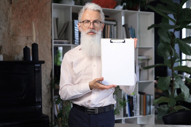 Confident pensive mature business man in modern office.