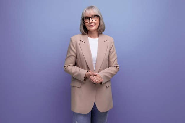 Confident s middle aged woman in stylish look smiling against bright studio background