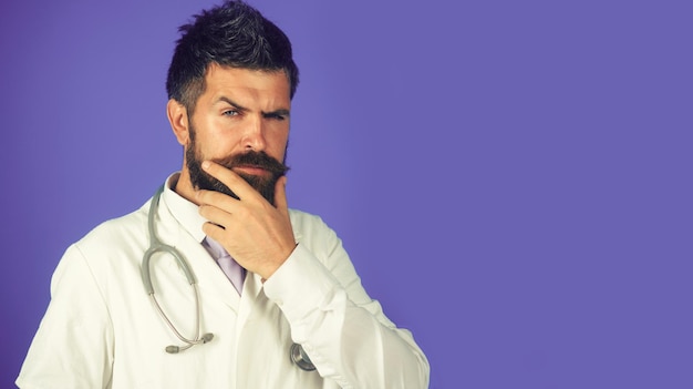 Confident serious male doctor with stethoscope bearded physician in white uniform copy space