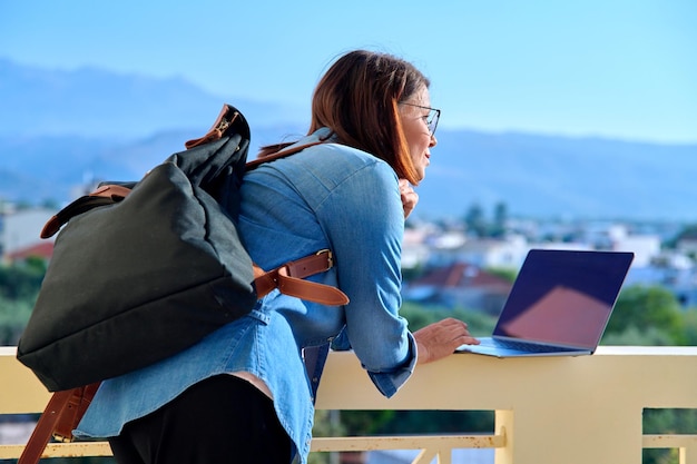 Confident serious mature business woman with laptop outdoors