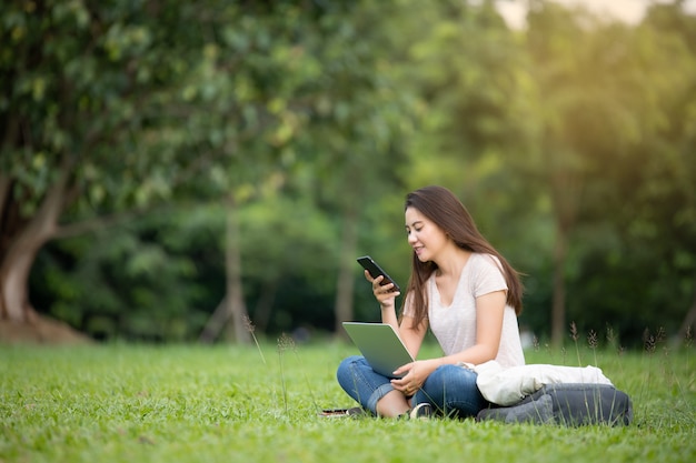 Confident smiling pretty young woman sitting on workplace in outdoor with laptop. Working concept