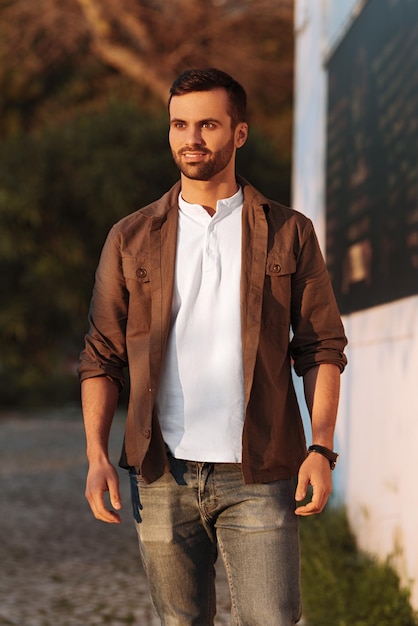 Confident smiling turkish guy standing on path in park