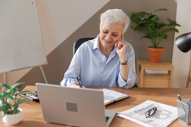 Confident stylish european middle aged senior woman using laptop at workplace stylish older mature s