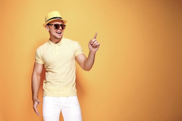 Confident stylish guy pointing at copyspace