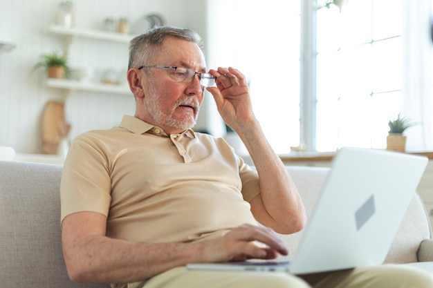 Confident stylish happy middle aged senior man using laptop at home stylish older mature s beard gra