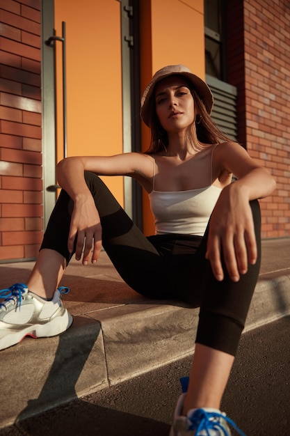 Confident stylish woman sitting on street