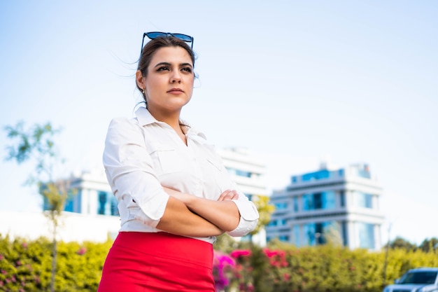 Confident and successful businesswoman in her workspace with a background of skyscrapers