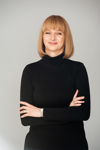 Confident woman in black dress on background