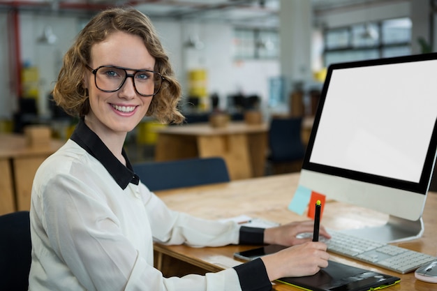 Confident woman sitting at desk in office