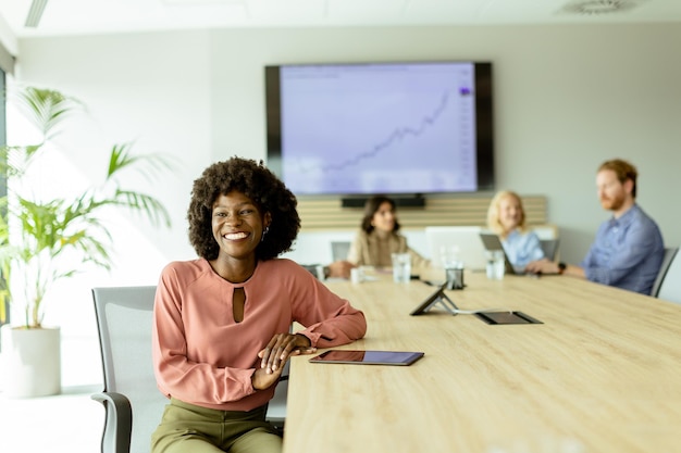 Confident young African American businesswoman smiling during a creative brainstorming session in a modern office