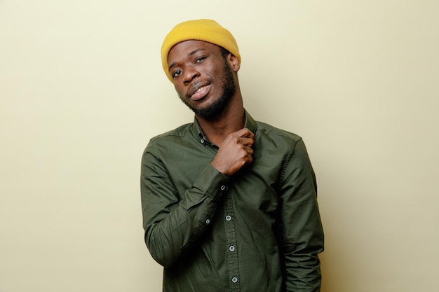 Confident young african american male in hat wearing green shirt isoloated on white background