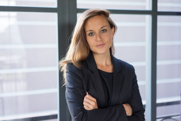 confident young beautiful brown-haired business woman looking at camera