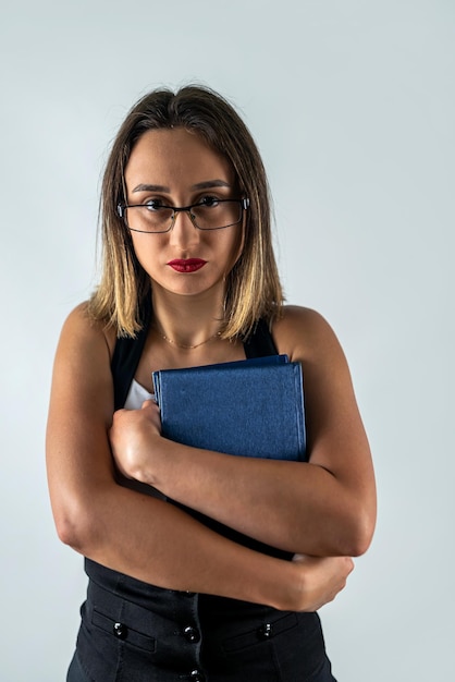 Confident young business woman teacher holding a book isolated on a white background Female studio portrait of a girl woman with books