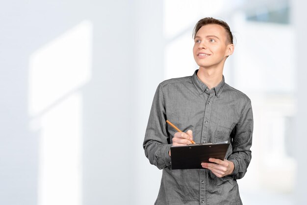 confident young man in shirt making notes in his pad