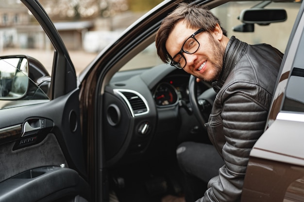 Confident young man sitting in a car