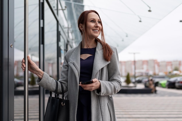 Confident young woman architect opens door of business center