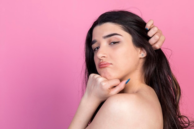 Confident young woman holding her hand to her head and looking at the camera High quality photo