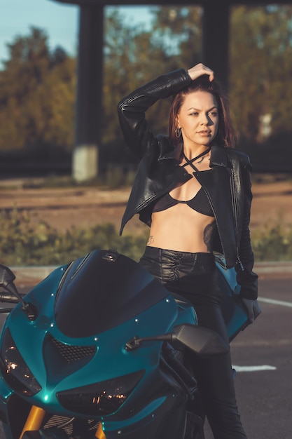 Confident young woman sitting on motorbike on parking area