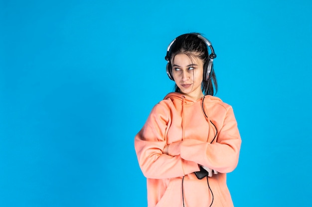 Confident young woman wearing headphones and looking aside