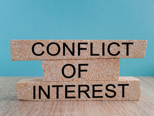 Conflict of interest symbol Brick blocks with words 'conflict of interest' Beautiful blue background