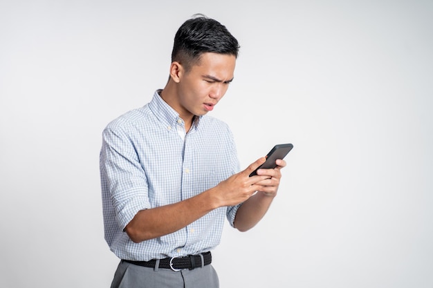 Confuse young businessman while looking at his smartphone