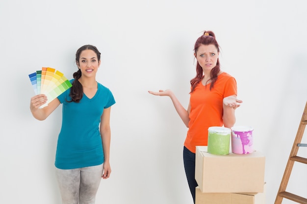 Confused friends choosing color for painting a room