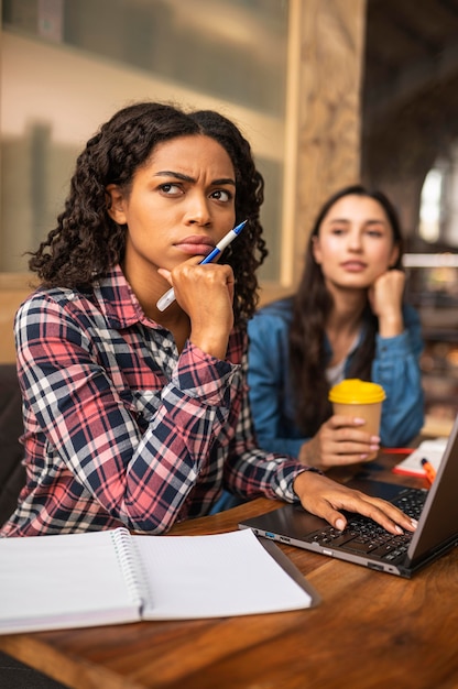 Confused friends doing homework together at a cafe