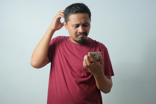 Confused gesture of man while looking phone screen