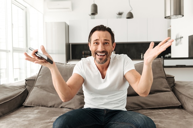 Confused mature man sitting on a sofa