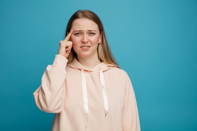 Confused young blonde woman doing think gesture 