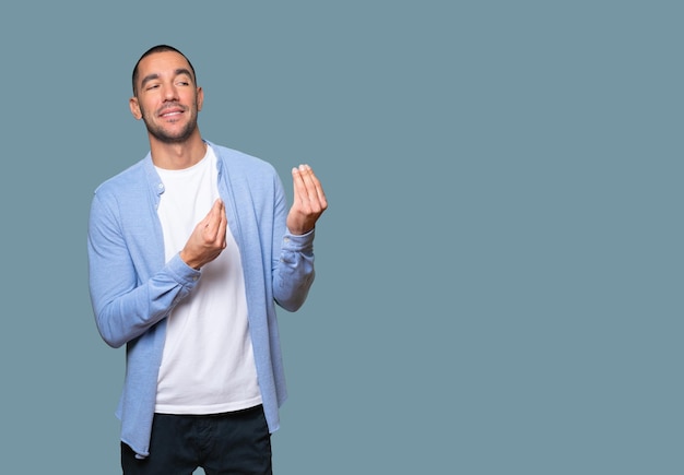 Confused young man making an italian gesture of not understanding