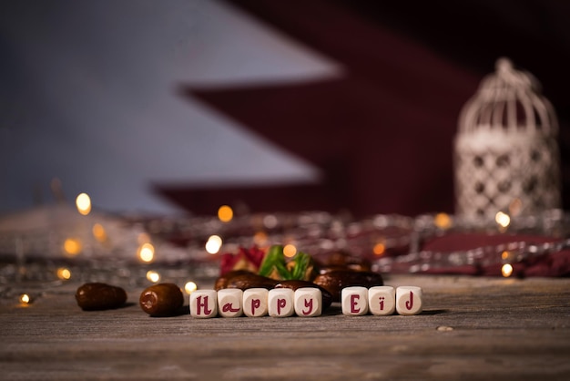 Congratulation HAPPY EID composed of wooden dices Flag of Qatar in the background