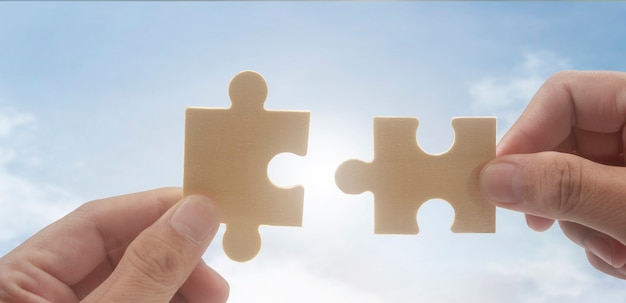 Connecting jigsaw puzzle in hand Business solutions success and strategy concept