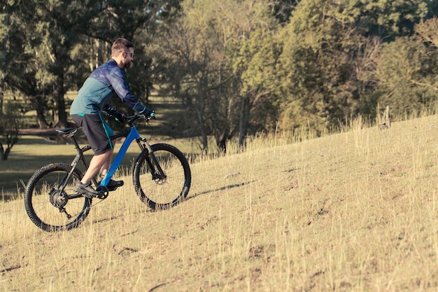 Conquering mountain peaks by cyclist in shorts and jersey on a modern carbon hardtail bike with an air suspension fork