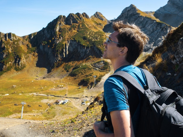 Conquering mountain peaks a young man makes a trip with a backpack in the mountains a traveler in a ...