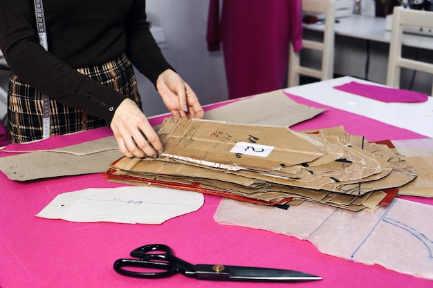 Photo conscious clothing zerowaste zerosweatshop fashion sewing sustainable fashion industry seamstress working with clothing and sewing pattern on table in tailor shop