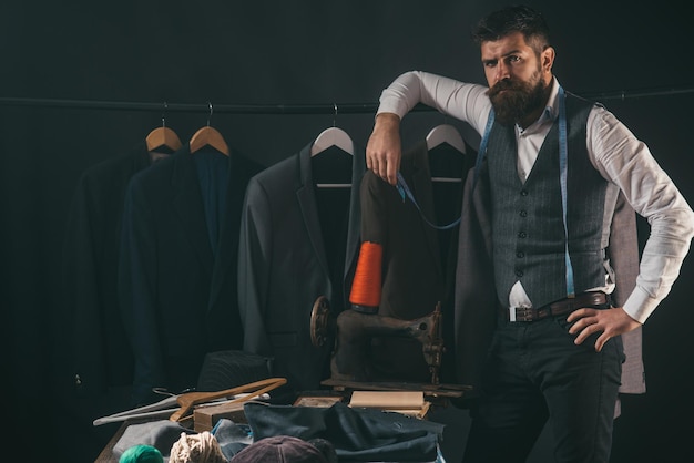 Considering the next step business dress code Handmade sewing mechanization retro and modern tailoring workshop Bearded man tailor sewing jacket suit store and fashion showroom Tailor sewing