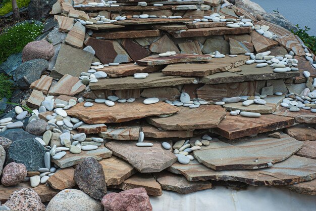 Construction of big round garden Alpine slide with stones and dwarf conifers and circular walking path