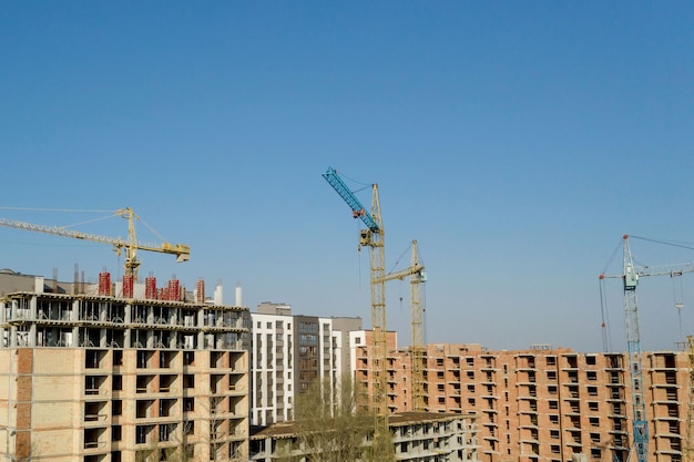 Construction and construction of high-rise buildings, the construction industry with working equipment and workers. View from above, from above. Background and texture.