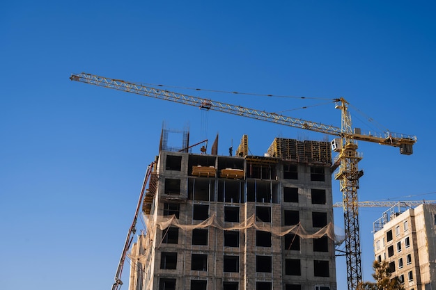 Construction crane is building a residential building on a construction site