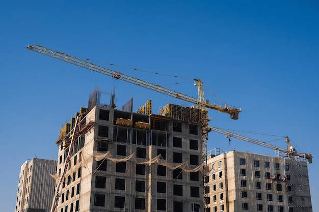 Construction crane is building a residential building on a construction site