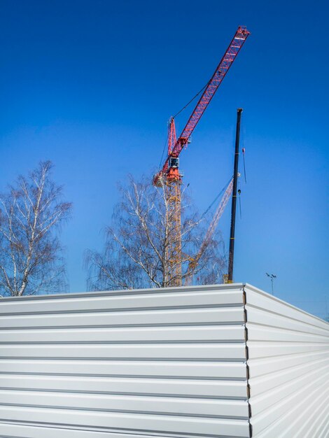 Construction cranes and metal wall outdoor copy space