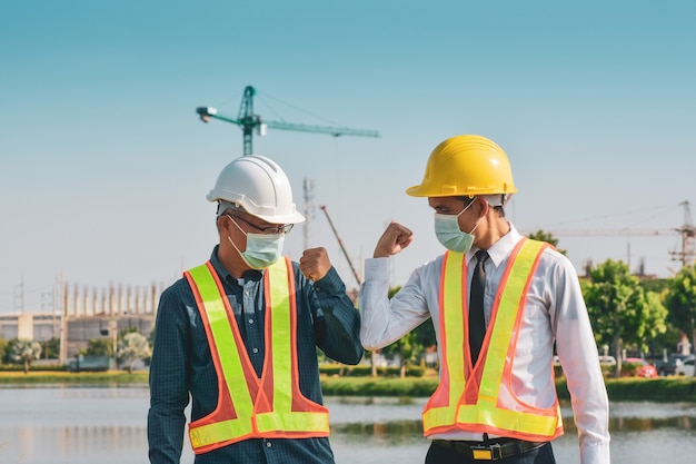 Construction engineer shake hand no touching on building construction site