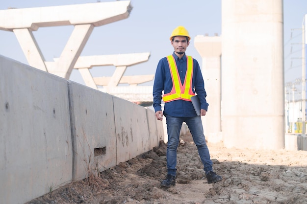 Construction Engineer using computer inspection on site highway road construction Construction worker using laptop