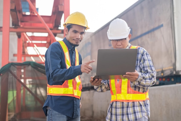 Construction Engineer using computer inspection on site highway road construction Construction worker using laptop